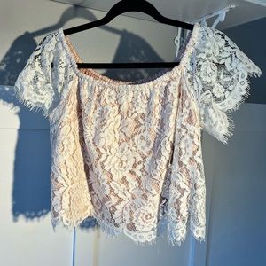 Cropped lace top with pink underlay.